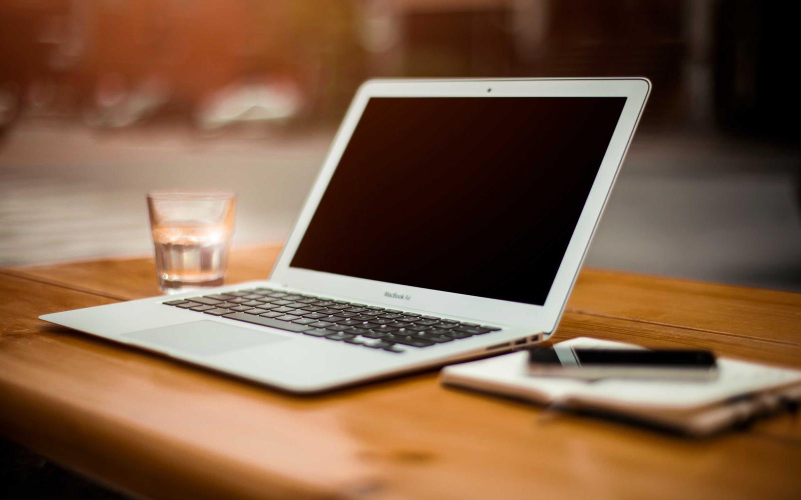 Un ordinateur portable ouvert sur une table en bois